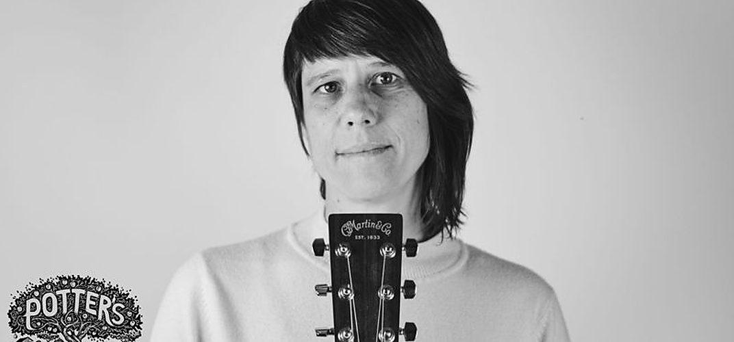 Black-and-white portrait of Tina holding an acoustic guitar beside the Potter's Craft Cider seal