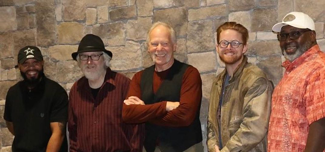 The five members of the Chickenhead Blues Band standing together against a stone wall